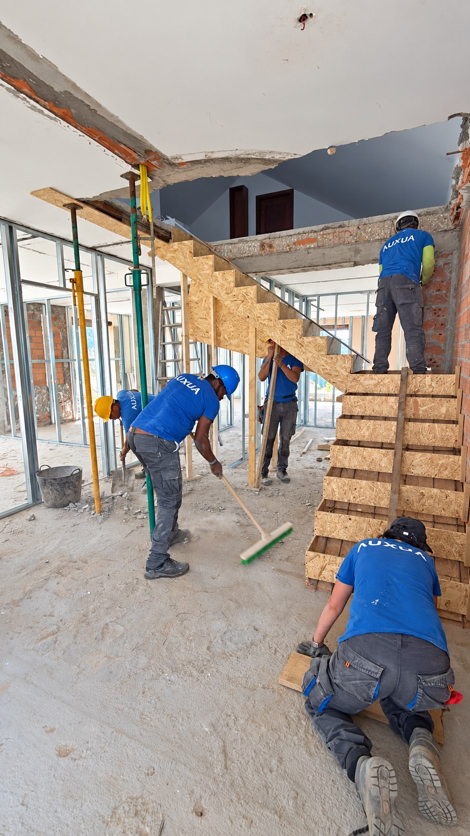 Equipo de AUXUA trabajando junto al encofrado de una escalera; fotografía retocada