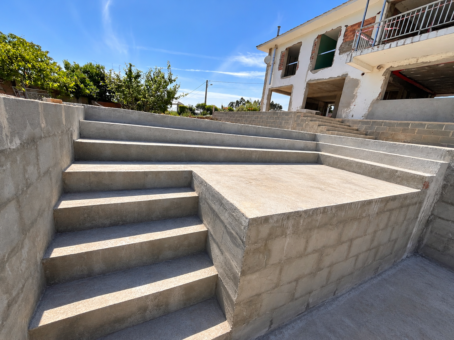 Escaleras, muros y plataformas de hormigón en una obra de Paderne; fotografía retocada