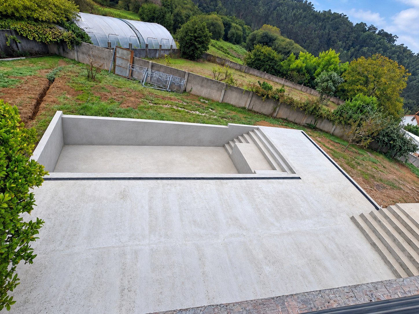 Vaso de piscina con escalera integrada; fotografía retocada con paredes alisadas digitalmente